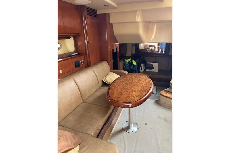 Slide: The Image of Interior of 2005 Sea Ray 390 Sundancer with wood table and beige seating. - 13