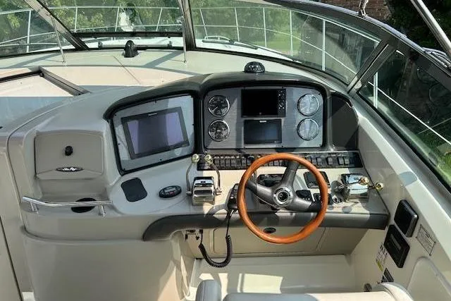 Slide: The Image of 2005 Sea Ray 390 Sundancer helm with modern controls and wooden steering wheel. - 17