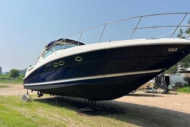 Slide: The Image of 2005 Sea Ray 390 Sundancer yacht on land, side view, clear sky background. - 2