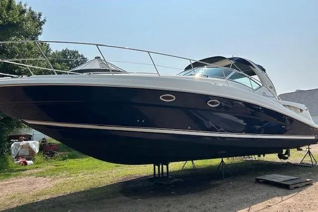 Slide: The Image of 2005 Sea Ray 390 Sundancer yacht on land, sleek design, blue hull, sunny day. - 3