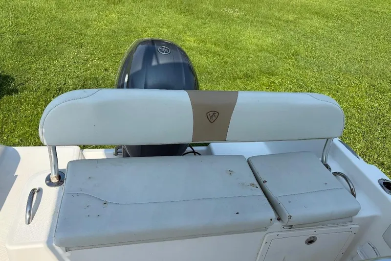 Slide: The Image of Century 2200 Center Console 2017 boat seat and engine, set on grassy background. - 12
