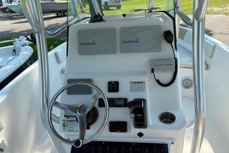 Slide: The Image of Century 2200 Center Console 2017 boat dashboard with Garmin navigation system and steering wheel. - 3