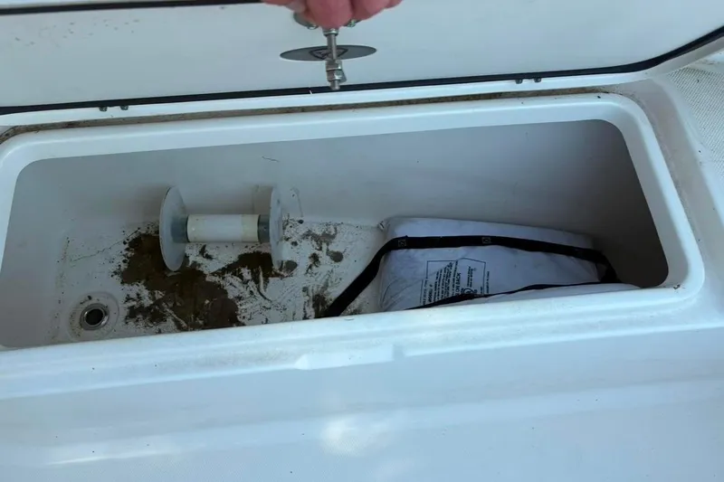 Slide: The Image of Open storage compartment on 2017 Century 2200 Center Console boat, containing a spool and bag. - 7