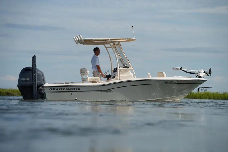 Slide: The Image of 2018 Grady-White 191 Coastal Explorer boat on calm water with a person at the helm. - 13