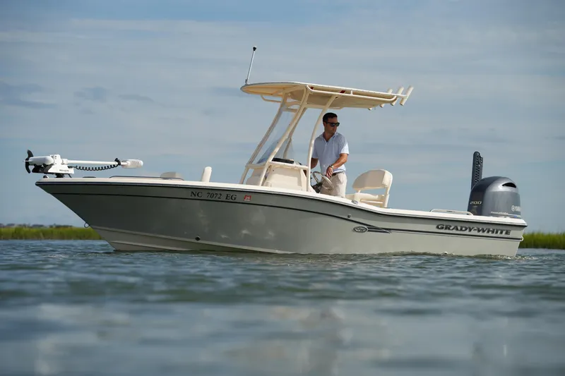 Slide: The Image of 2018 Grady-White 191 Coastal Explorer boat on water, man steering, clear sky background. - 3