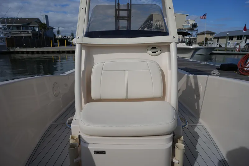 Slide: The Image of 2018 Grady-White 191 Coastal Explorer boat interior with cushioned seating at marina. - 35