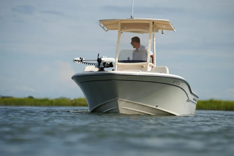 Slide: The Image of 2018 Grady-White 191 Coastal Explorer boat on calm water, with a person at the helm. - 6