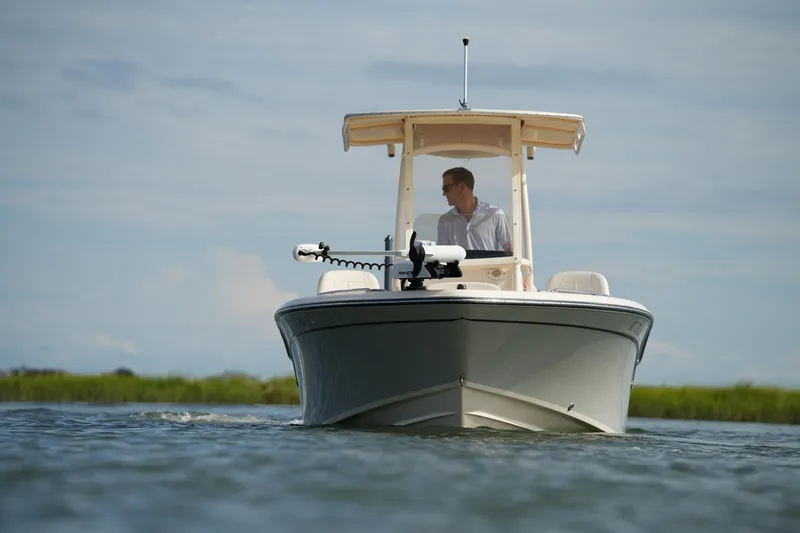 Slide: The Image of 2018 Grady-White 191 Coastal Explorer boat on water, with person at helm. - 7