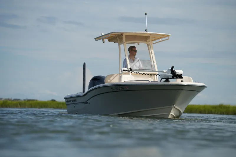 Slide: The Image of 2018 Grady-White 191 Coastal Explorer boat on calm water, with a person at the helm. - 9