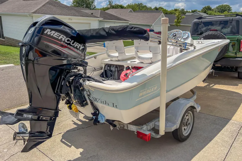 Slide: The Image of 2016 Boston Whaler 130 Super Sport boat on trailer with Mercury outboard motor. - 2