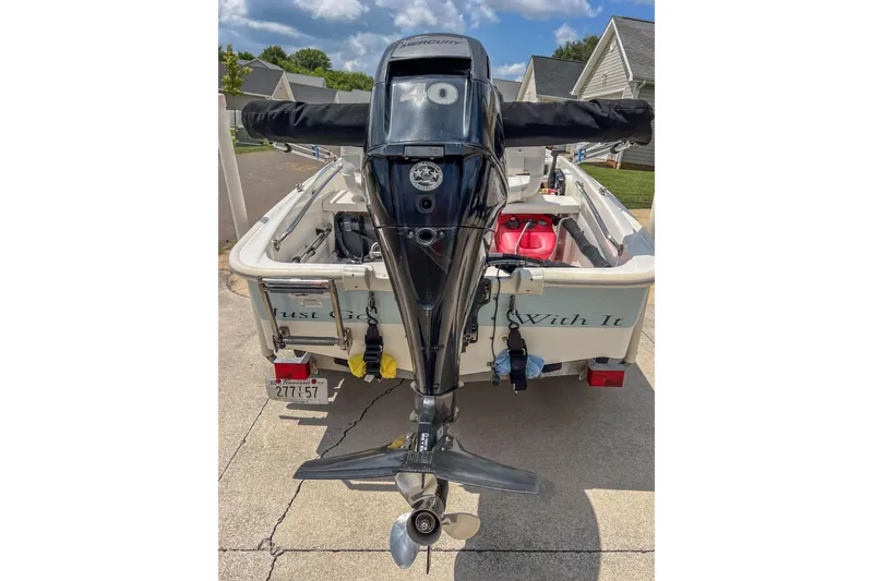 Slide: The Image of 2016 Boston Whaler 130 Super Sport boat with Mercury outboard motor, parked in driveway. - 3