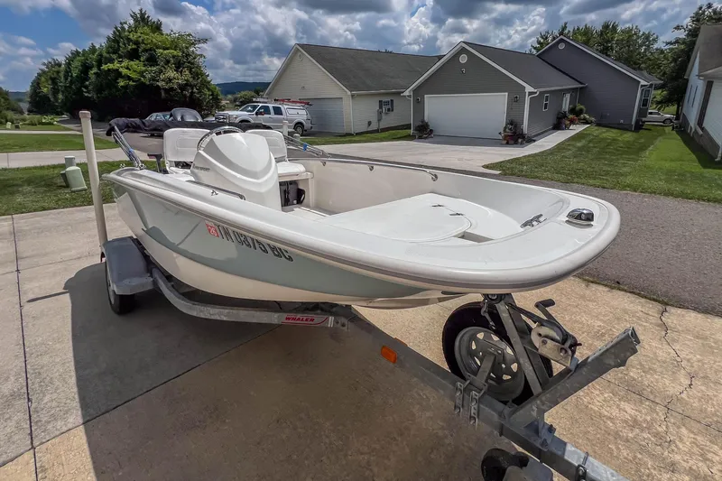 Slide: The Image of 2016 Boston Whaler 130 Super Sport boat on trailer in residential driveway. - 6
