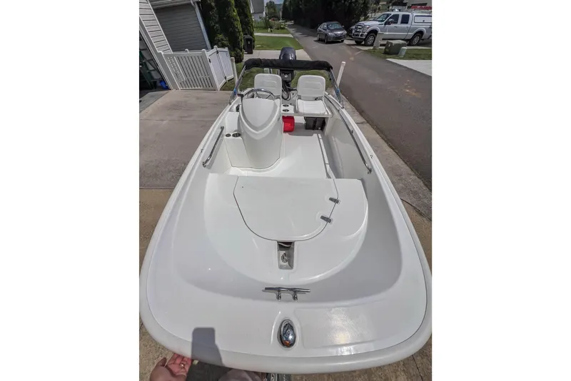 Slide: The Image of 2016 Boston Whaler 130 Super Sport boat parked in a driveway, showcasing sleek design. - 7
