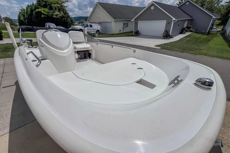 Slide: The Image of 2016 Boston Whaler 130 Super Sport boat parked in a residential driveway. - 8