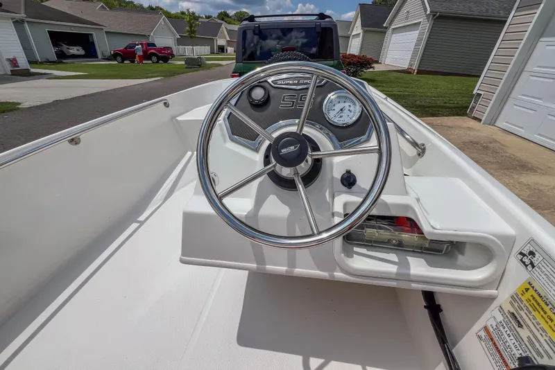 Slide: The Image of 2016 Boston Whaler 130 Super Sport boat dashboard with steering wheel and gauges. - 9