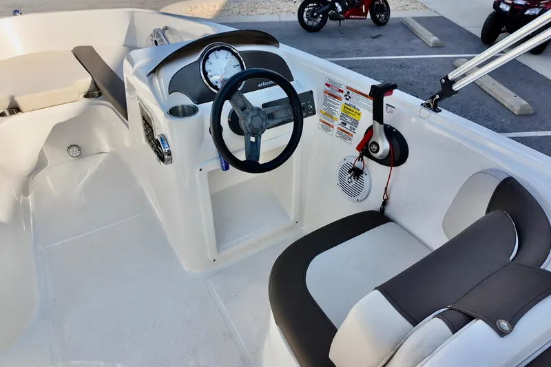 Slide: The Image of 2021 Bayliner Element E18 boat interior with steering wheel and seating area. - 6