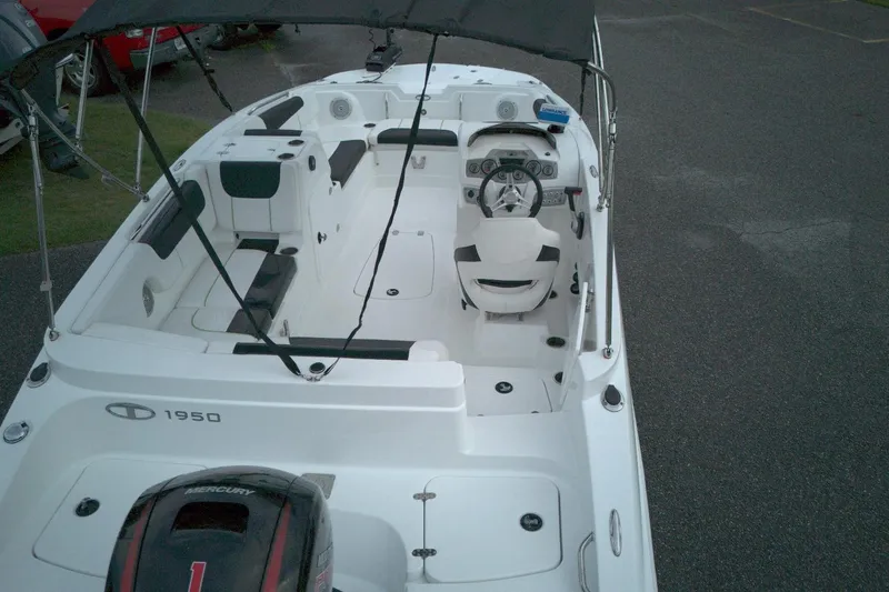 Slide: The Image of 2021 Tahoe 1950 boat interior with seating and steering wheel, parked on asphalt. - 7