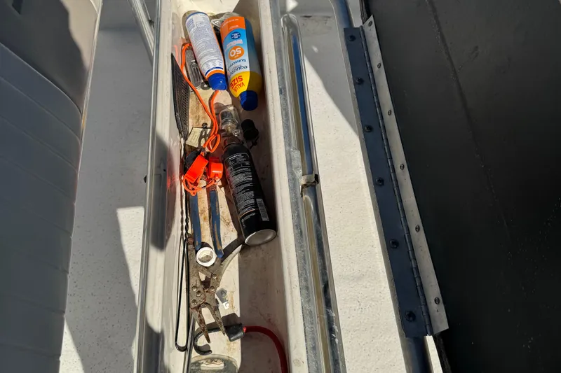 Slide: The Image of Storage compartment on 2014 Carolina Skiff 218 DLV with tools and sunscreen. - 10