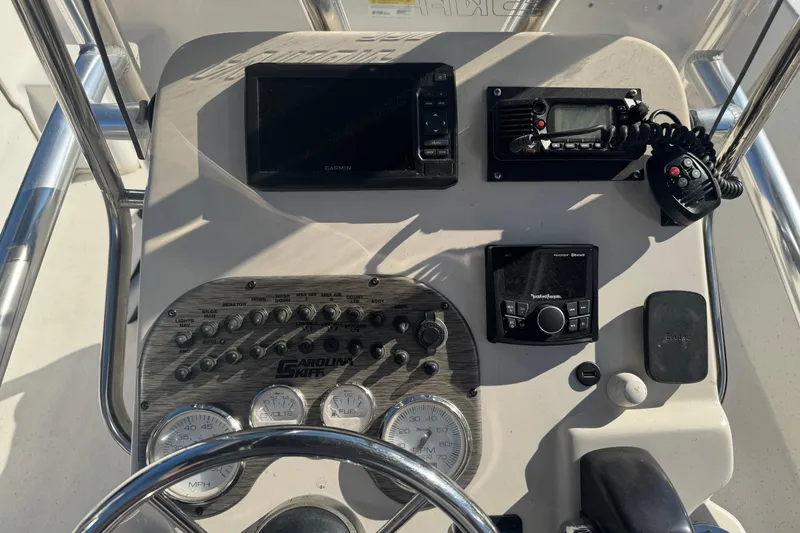 Slide: The Image of 2014 Carolina Skiff 218 DLV dashboard with Garmin navigation and control panel. - 5