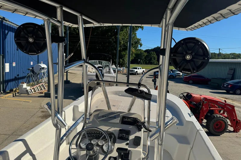 Slide: The Image of 2014 Carolina Skiff 218 DLV boat with T-top and speakers, docked outdoors. - 8