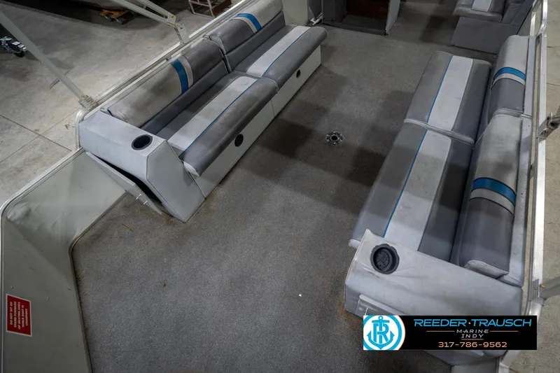 Slide: The Image of 1992 Sun Tracker Party Barge 24 pontoon boat with blue canopy in indoor storage. - 12