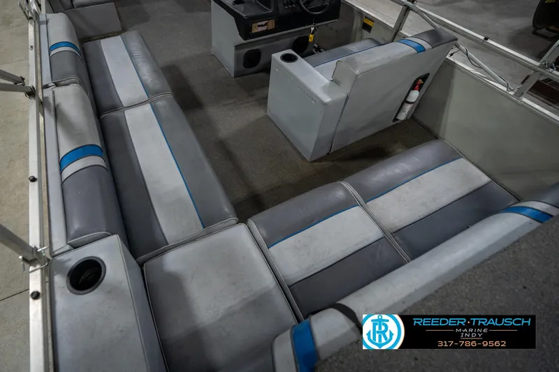 Slide: The Image of 1992 Sun Tracker Party Barge 24 interior with gray seating and steering console. - 15