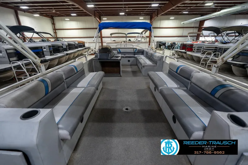 Slide: The Image of 1992 Sun Tracker Party Barge 24 interior with gray seating and steering console. - 16