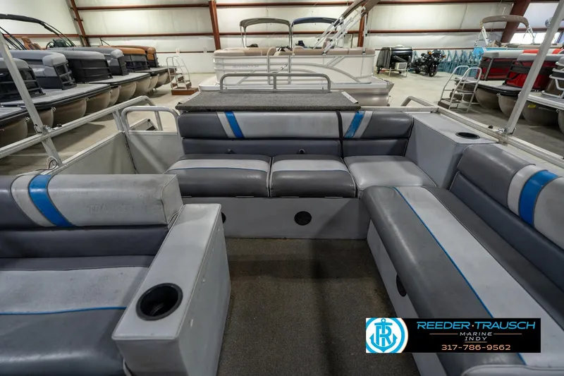 Slide: The Image of 1992 Sun Tracker Party Barge 24 with blue canopy and spacious seating in showroom. - 18