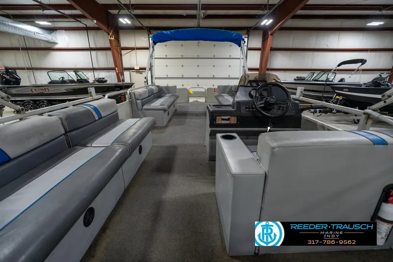 Slide: The Image of 1992 Sun Tracker Party Barge 24 pontoon boat interior with gray seating in showroom. - 19