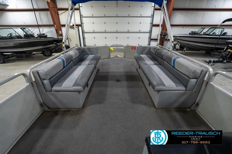 Slide: The Image of 1992 Sun Tracker Party Barge 24 interior with gray seating and steering wheel in a showroom. - 20