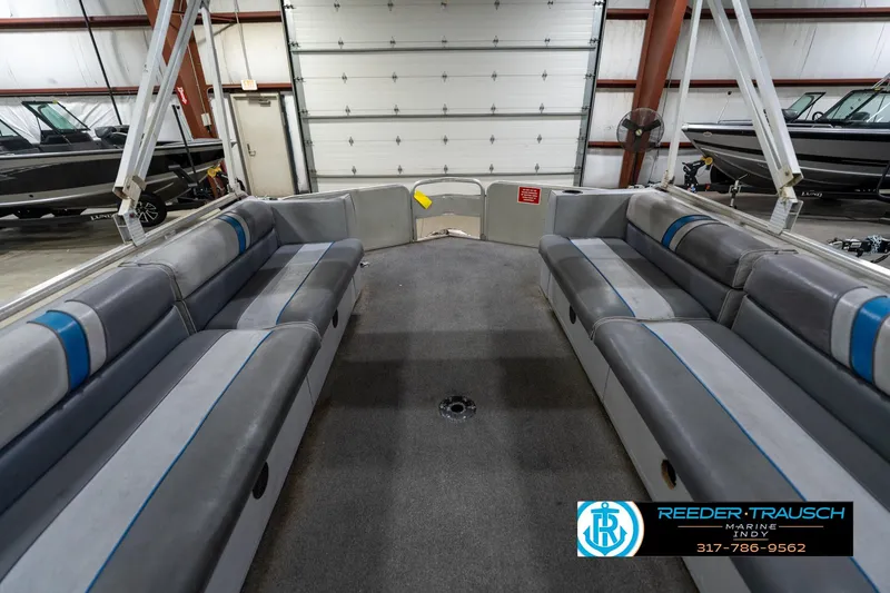 Slide: The Image of 1992 Sun Tracker Party Barge 24 interior with gray seating in a showroom. - 21