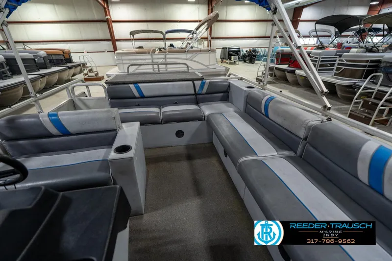 Slide: The Image of 1992 Sun Tracker Party Barge 24 interior with gray seating in a showroom. - 23