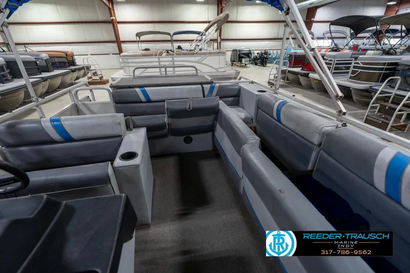 Slide: The Image of 1992 Sun Tracker Party Barge 24 pontoon boat interior with gray seating in a showroom. - 24