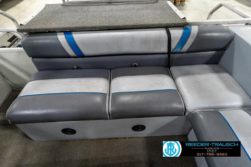 Slide: The Image of Interior of a 1992 Sun Tracker Party Barge 24 with gray seating and cup holder. - 32