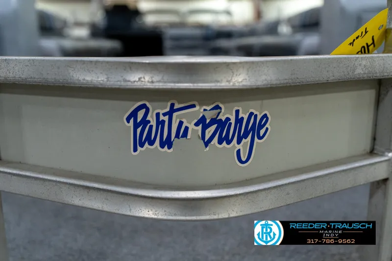 Slide: The Image of 1992 Sun Tracker Party Barge 24 with Evinrude outboard motor in a showroom. - 39