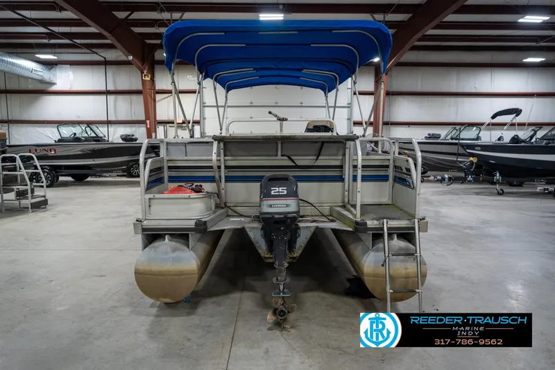 Slide: The Image of 1992 Sun Tracker Party Barge 24 pontoon boat with blue canopy in indoor storage. - 9