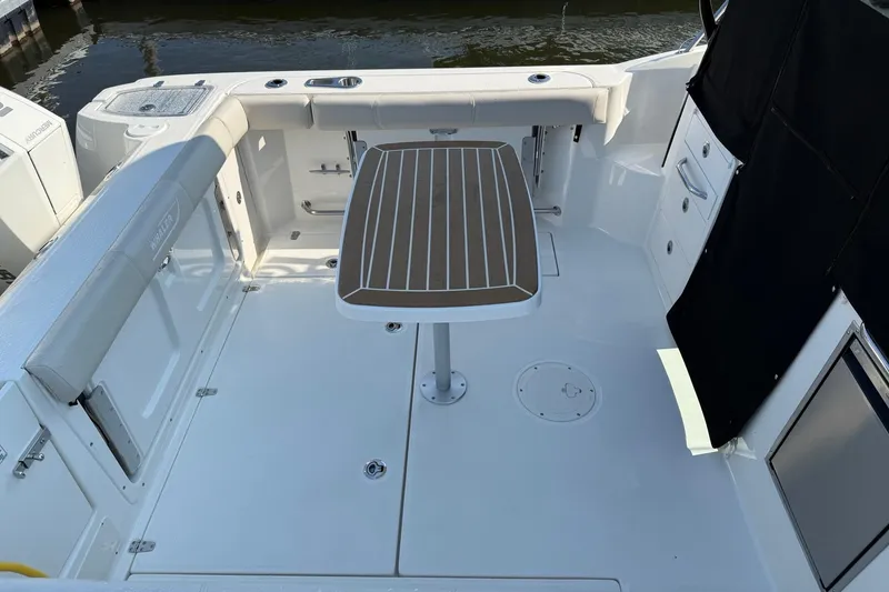 Slide: The Image of 2026 Boston Whaler 285 Conquest boat deck with table and seating area. - 12