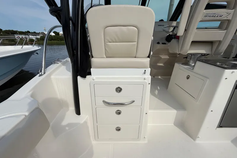 Slide: The Image of 2026 Boston Whaler 285 Conquest interior with seating and storage drawers. - 16
