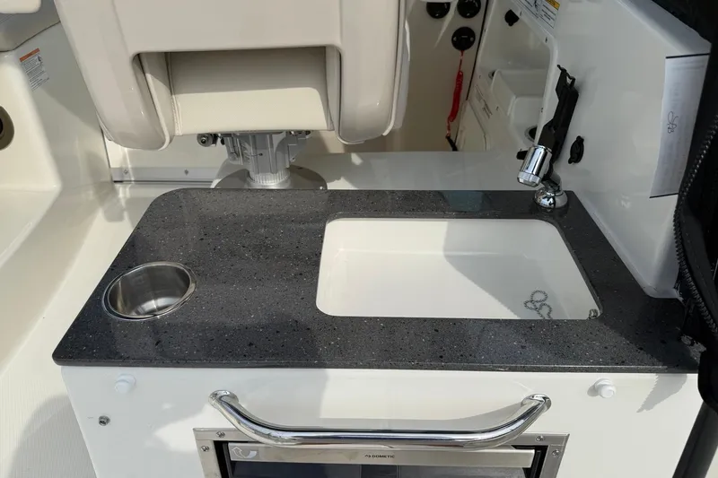Slide: The Image of 2026 Boston Whaler 285 Conquest boat interior with sink and countertop detail. - 18
