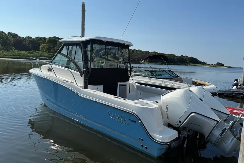 Slide: The Image of 2026 Boston Whaler 285 Conquest boat docked on calm water. - 2