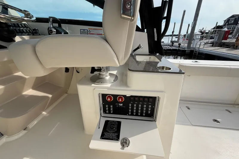 Slide: The Image of 2026 Boston Whaler 285 Conquest cockpit with control panel and seating, docked at marina. - 20