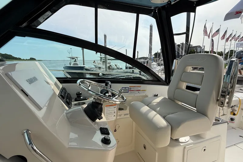 Slide: The Image of 2026 Boston Whaler 285 Conquest helm with steering wheel and comfortable seating. - 21