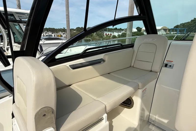 Slide: The Image of 2026 Boston Whaler 285 Conquest interior seating with beige upholstery and sleek design. - 25