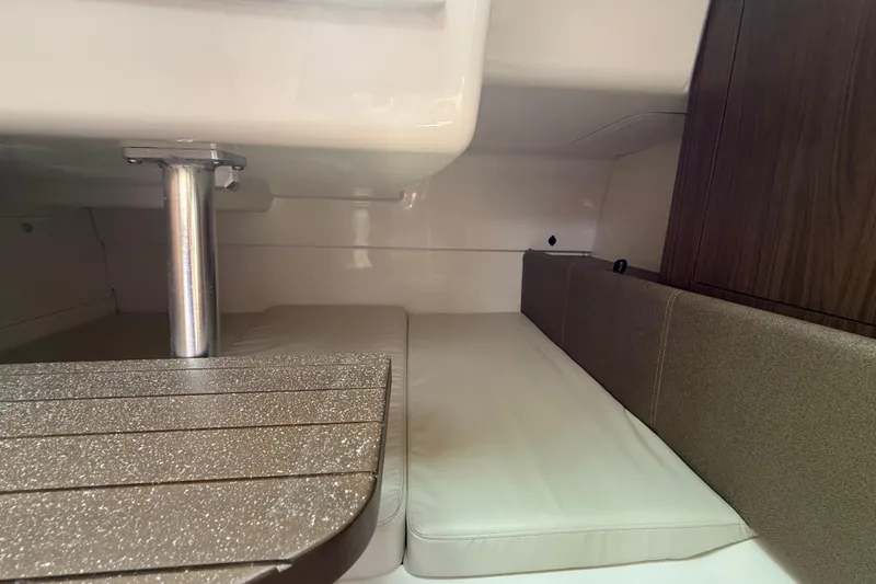 Slide: The Image of 2026 Boston Whaler 285 Conquest cabin interior with cushioned seating and wooden accents. - 38