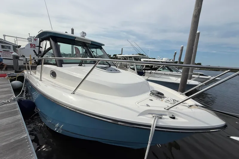 Slide: The Image of 2026 Boston Whaler 285 Conquest docked, showcasing sleek design and blue hull. - 40
