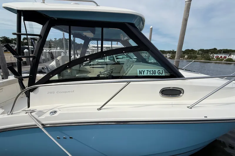 Slide: The Image of 2026 Boston Whaler 285 Conquest boat docked, featuring sleek design and blue hull. - 41