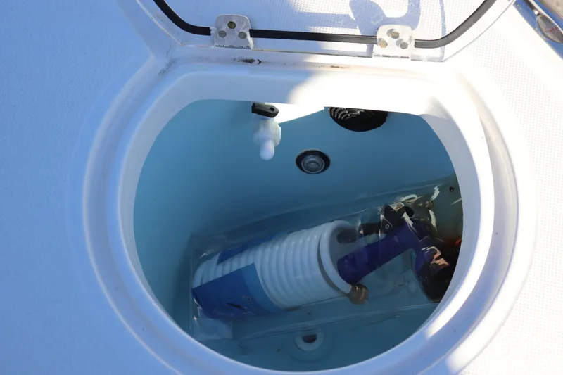Slide: The Image of 2024 Sea Born LX24 Center Console storage compartment with coiled hose and fittings. - 13