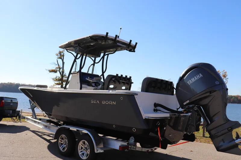 Slide: The Image of 2024 Sea Born LX24 Center Console boat on trailer by a lake. - 15