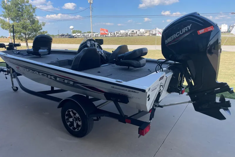 Slide: The Image of 2021 Bass Tracker PT175 boat with Mercury engine on a trailer, parked outdoors. - 3