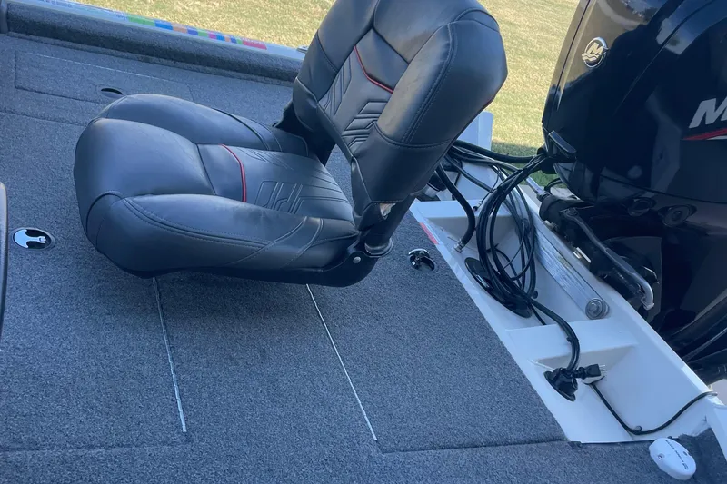 Slide: The Image of 2021 Bass Tracker PT175 boat interior with seat and motor, showcasing fishing setup. - 5